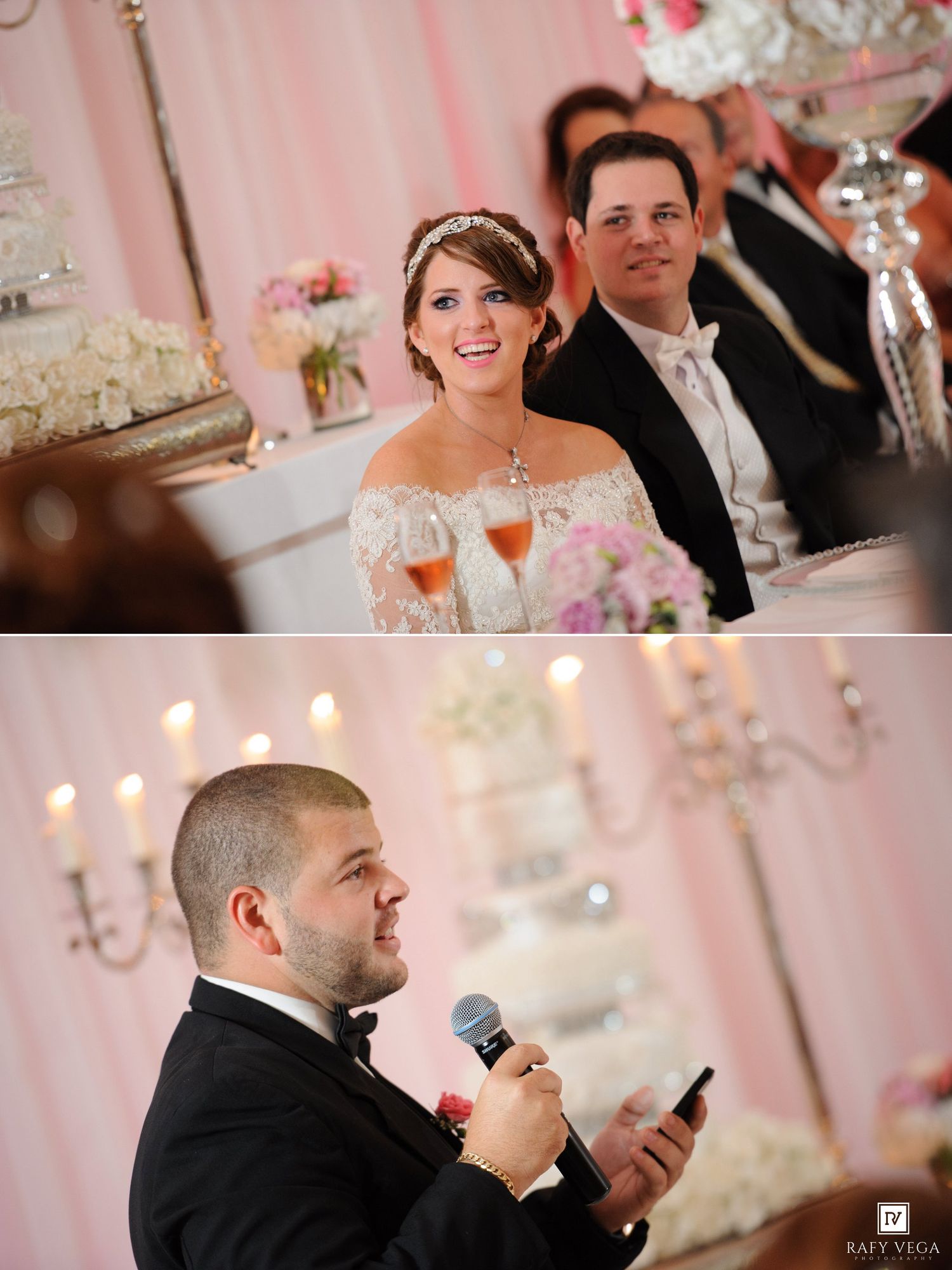 Bride smiling at wedding reception head table with groom, while best man gives a toast holding microphone and phone.