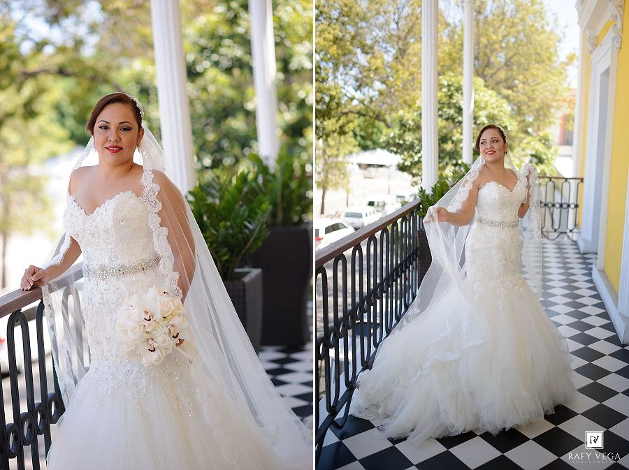 Bride in lace mermaid wedding gown with veil poses on a classic black and white checkered balcony.