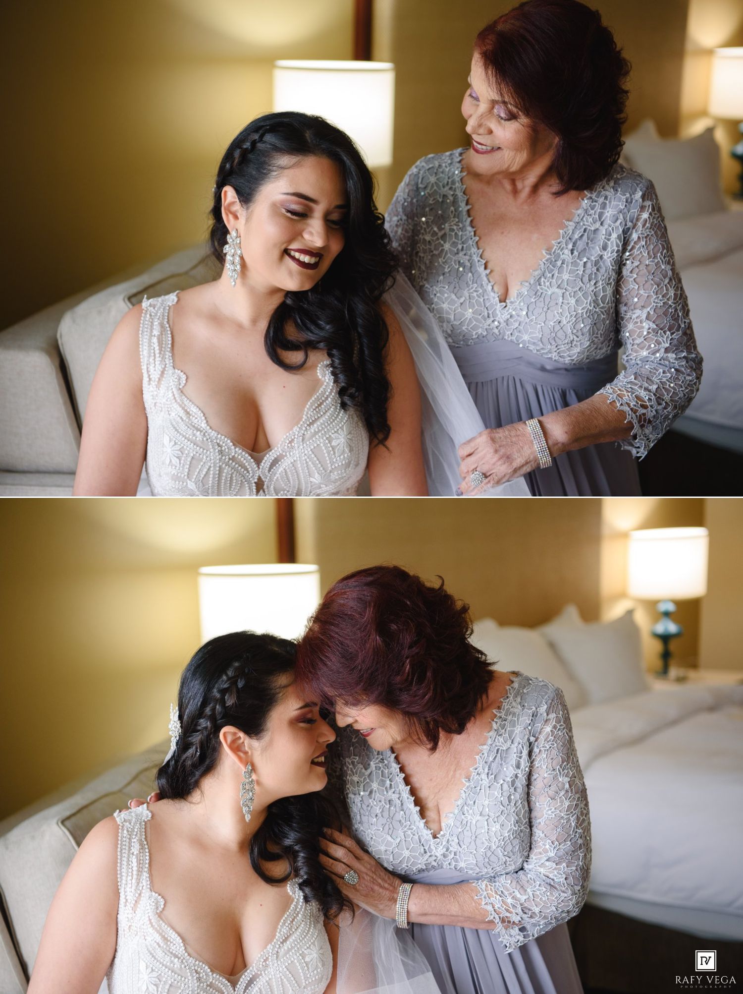 Bride in white lace gown laughing with older woman in silver dress during wedding preparations.
