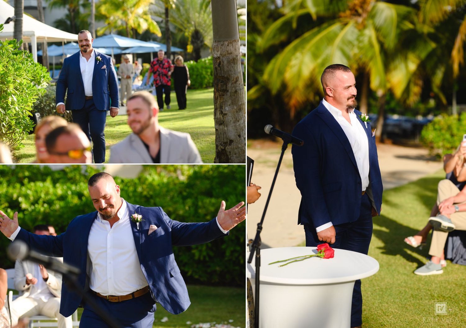 Groom in navy blazer smiling at outdoor wedding ceremony surrounded by palm trees and guests in sunny tropical setting.