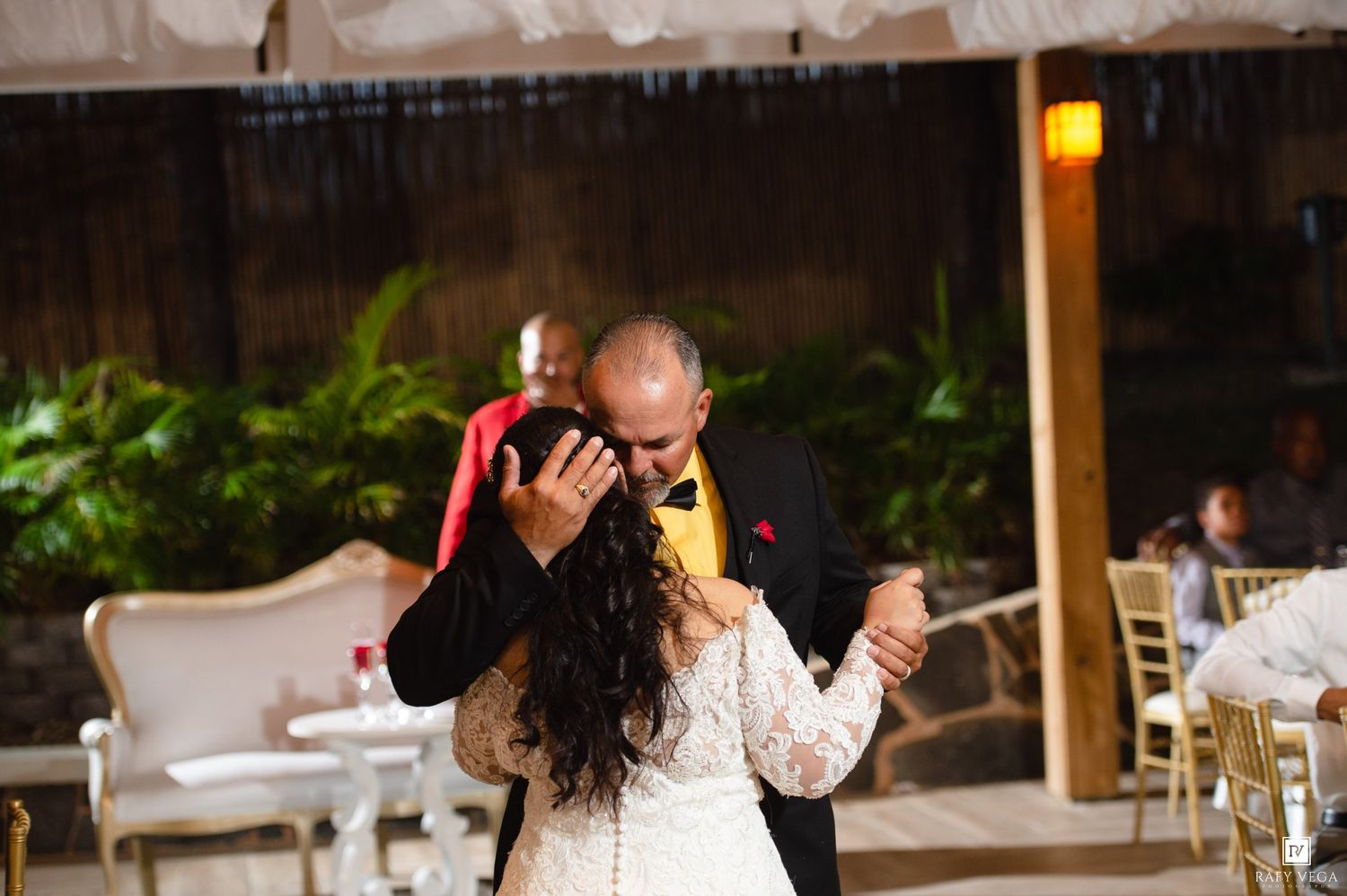 Bride and groom share an emotional first dance embrace at outdoor wedding reception.
