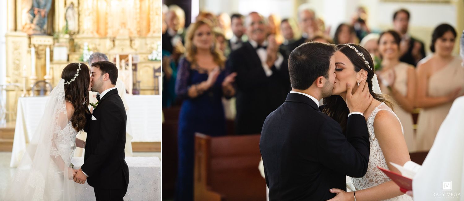 Bride and groom share their first kiss at the altar during a church wedding ceremony.