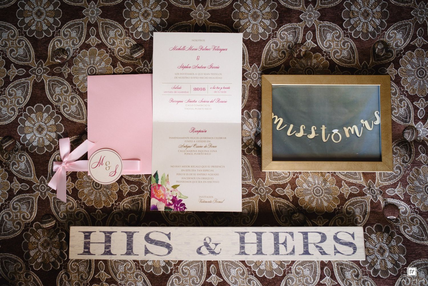 Elegant wedding stationery suite with pink invitation, navy blue envelope, and His & Hers wooden sign on floral background.