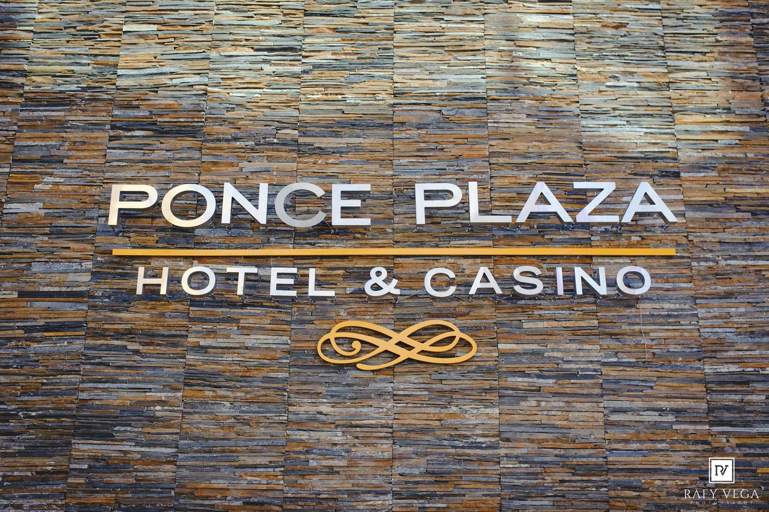 Sign for Ponce Plaza Hotel & Casino mounted on a decorative stone wall with elegant white lettering and gold accents.