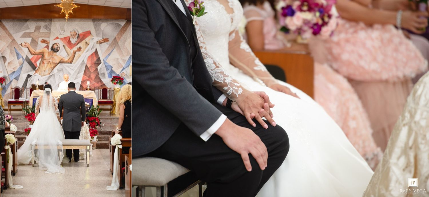 A bride and groom hold hands during their church wedding ceremony, with guests and floral arrangements visible in the background.
