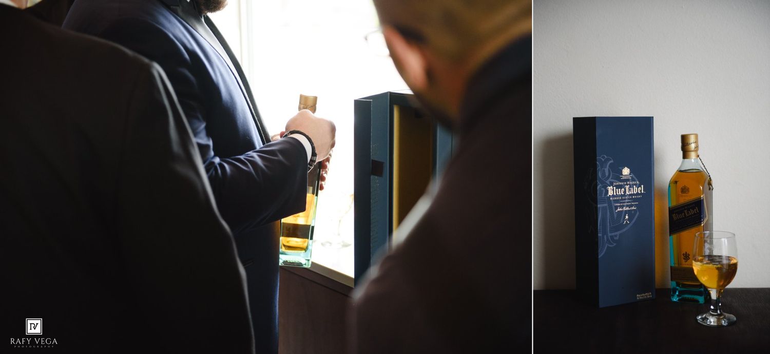 Groom holding Johnnie Walker Blue Label whisky bottle during wedding preparations with gift box displayed nearby.