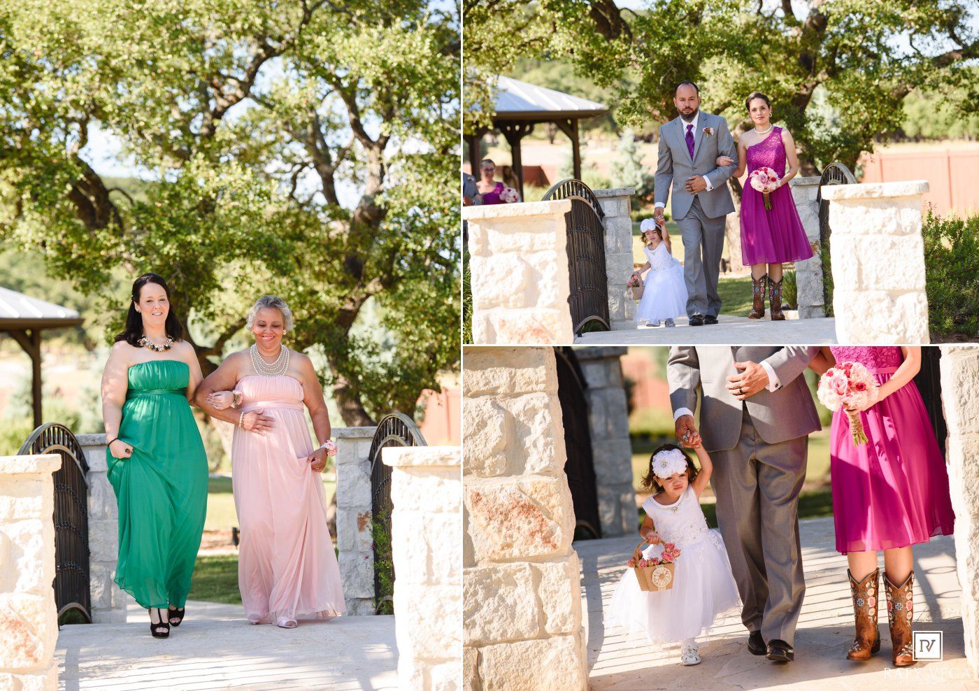 Wedding party walks down outdoor aisle, bridesmaids in green and pink dresses with groomsmen and flower girl at stone venue.