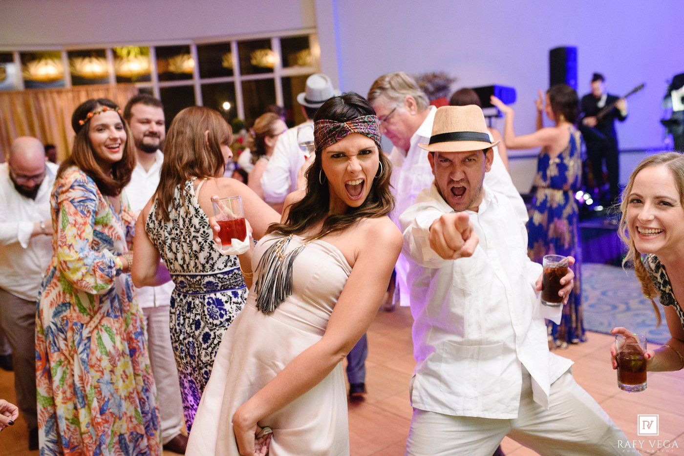 Guests dancing and celebrating at a lively wedding reception party indoors.