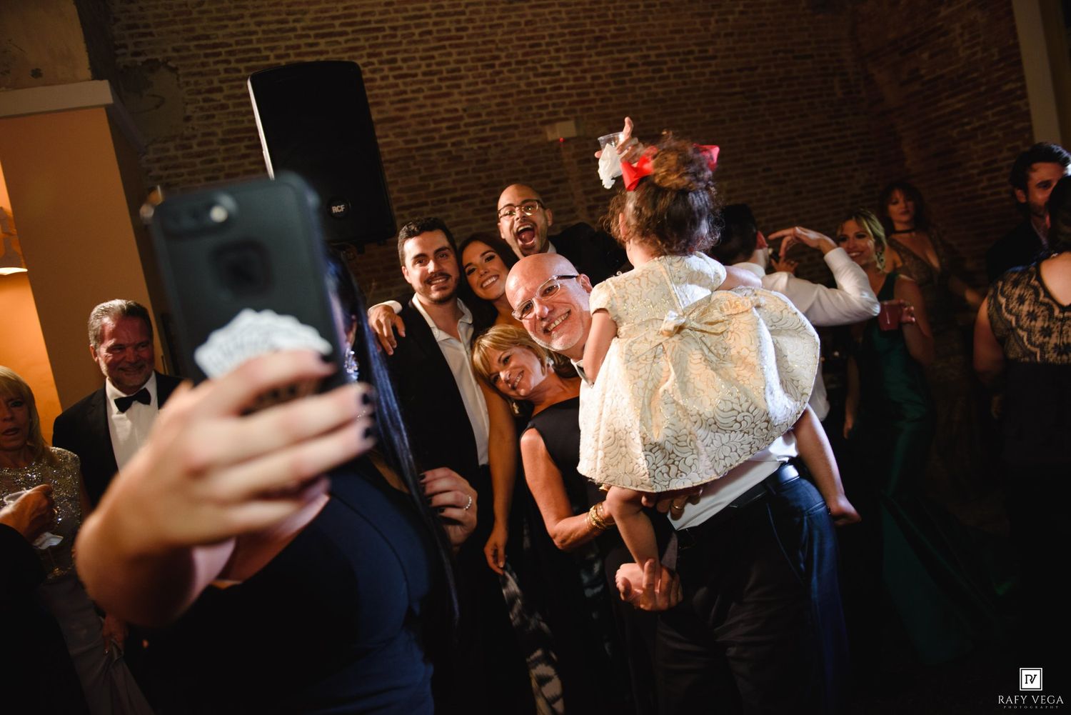 Wedding guests taking a fun selfie on the dance floor during reception party.