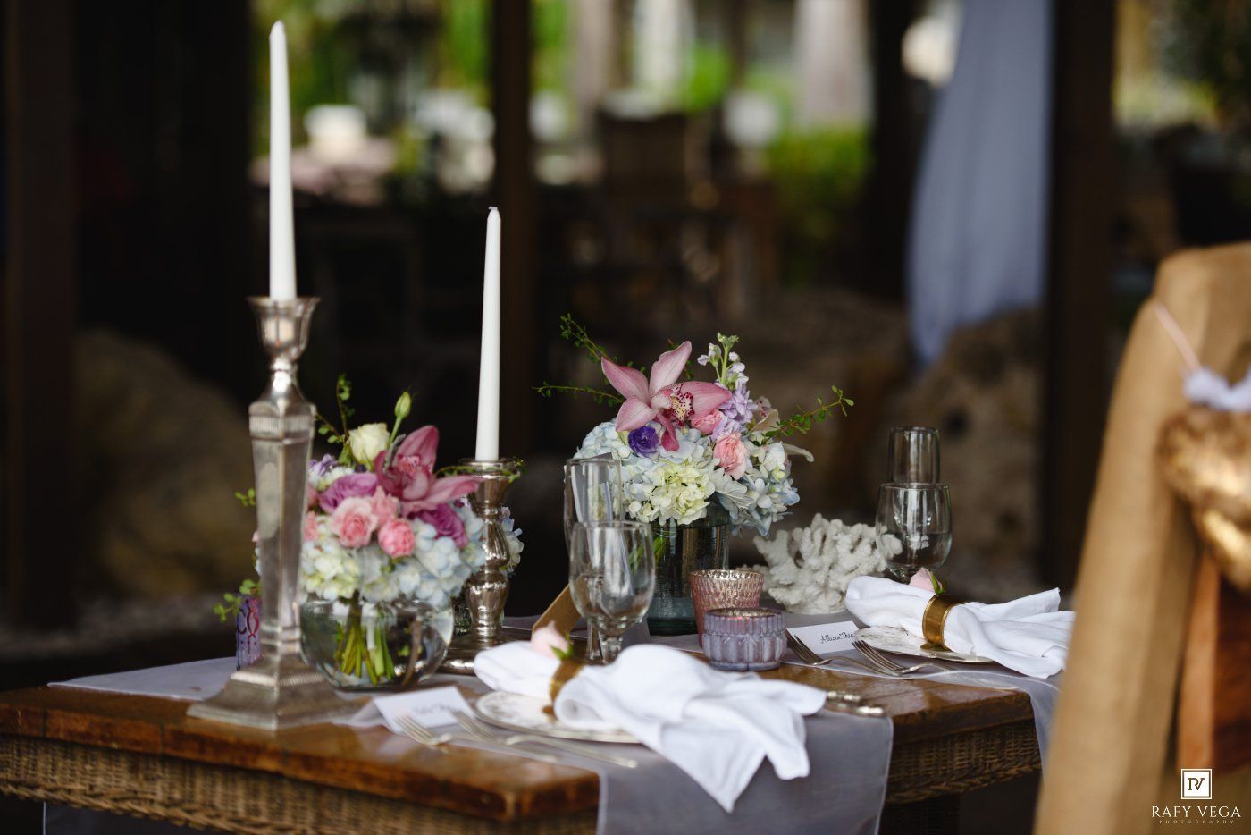 Romantic wedding sweetheart table with silver candelabras, mixed floral arrangements, and elegant place settings.
