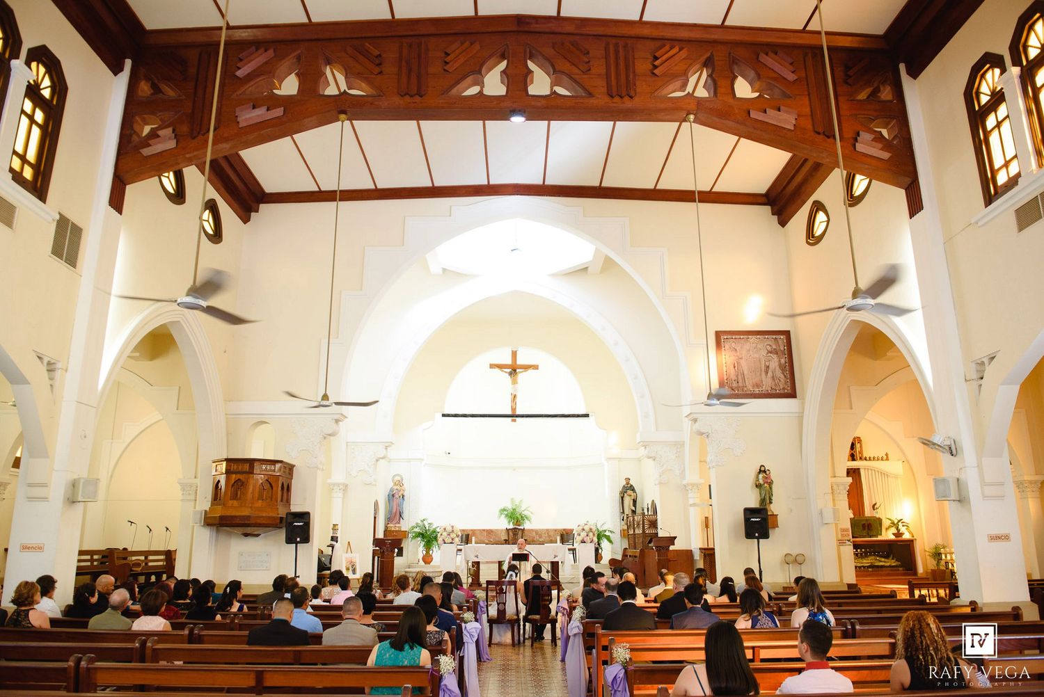 Interior of a beautiful church filled with wedding guests during a ceremony.