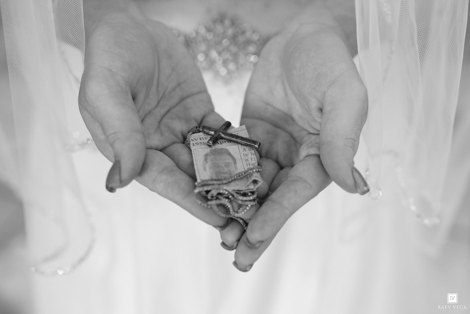 Bride holding coins and small items in cupped hands, a wedding unity ceremony tradition, black and white photo.