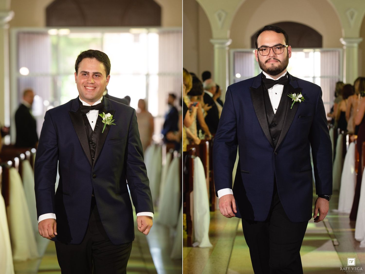 Two groomsmen in navy tuxedos with bow ties and boutonnieres walk down a church aisle at a wedding.