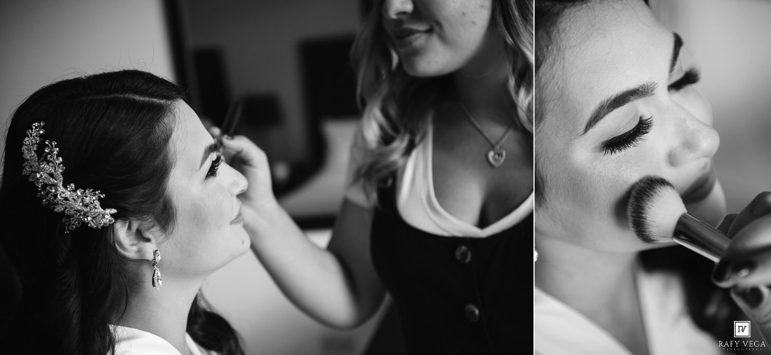 Black and white photo of a bride getting makeup applied by a professional makeup artist before her wedding.