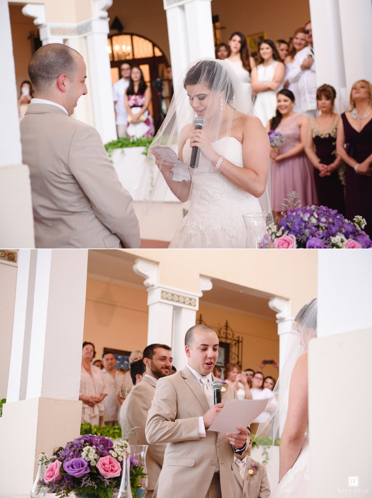 Bride reads wedding vows into microphone in white gown and veil while groom listens during outdoor ceremony.