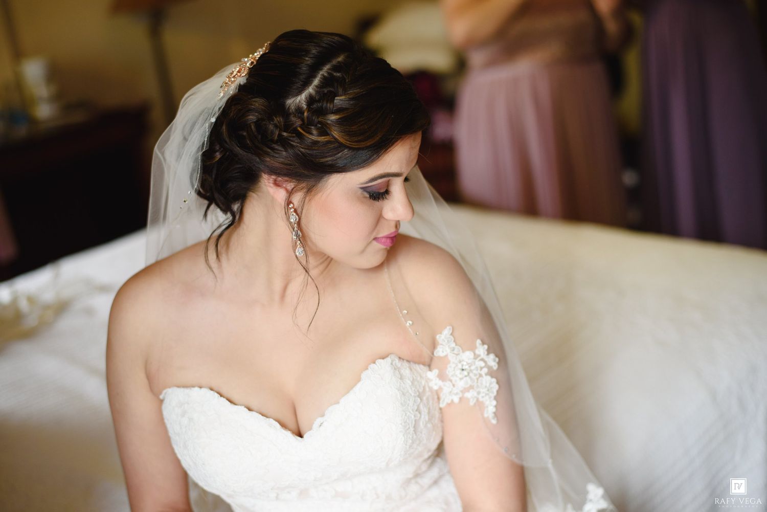 Beautiful bride in lace wedding gown with veil and elegant updo hairstyle.
