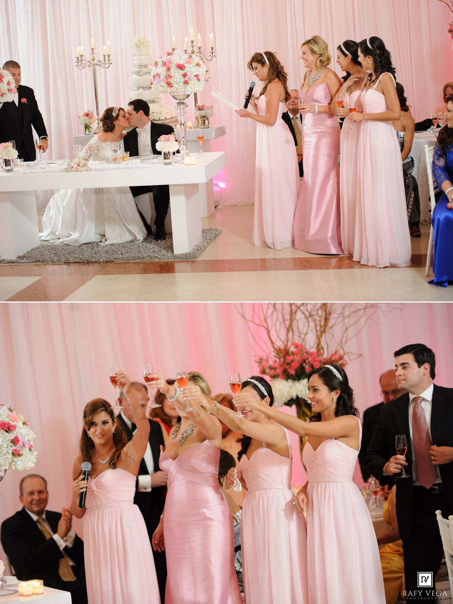 Bridesmaids in pink gowns toast at a wedding reception while the bride and groom sit at a white sweetheart table.