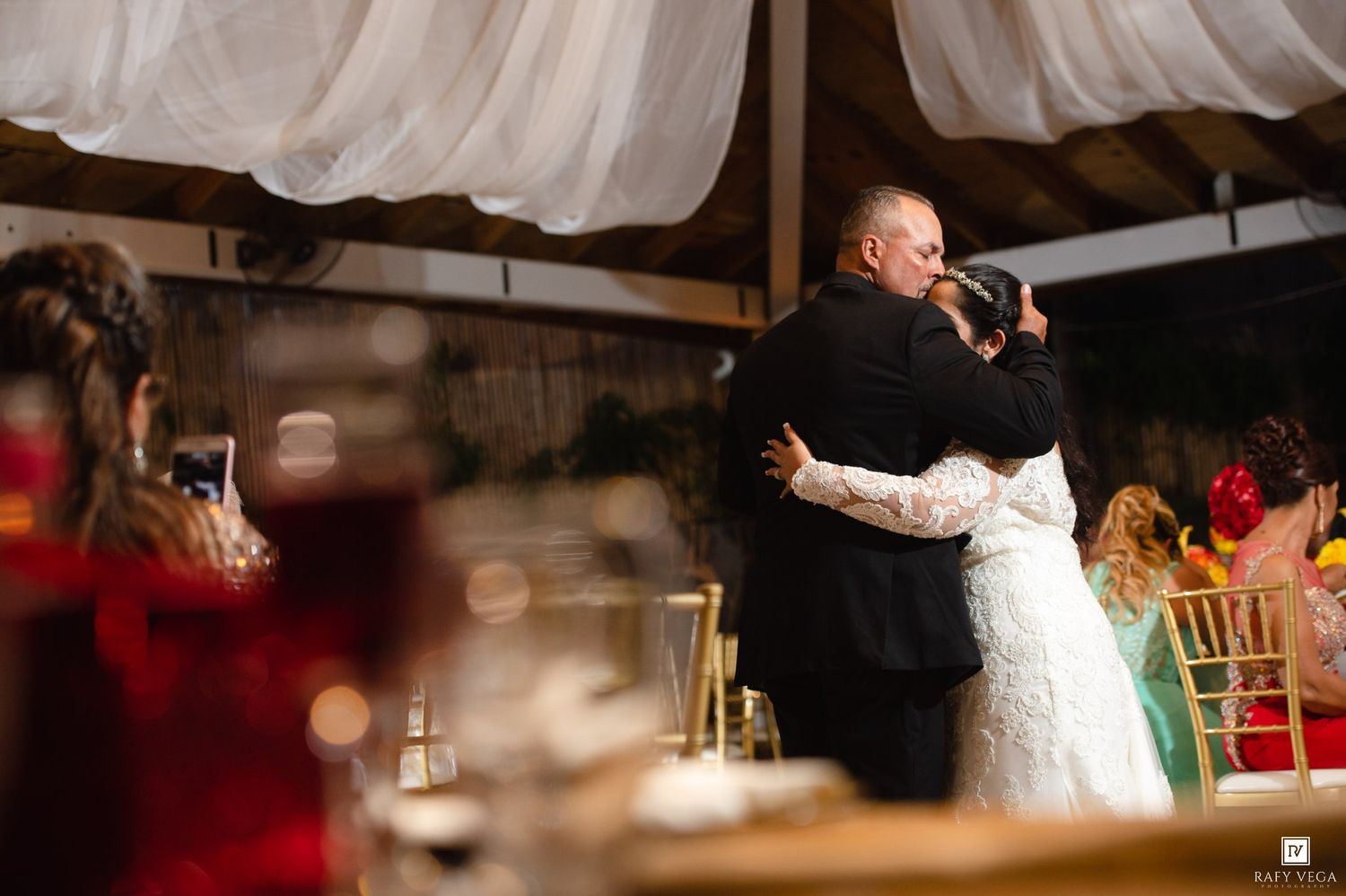 Bride and groom share a tender first dance embrace at an elegant wedding reception venue.