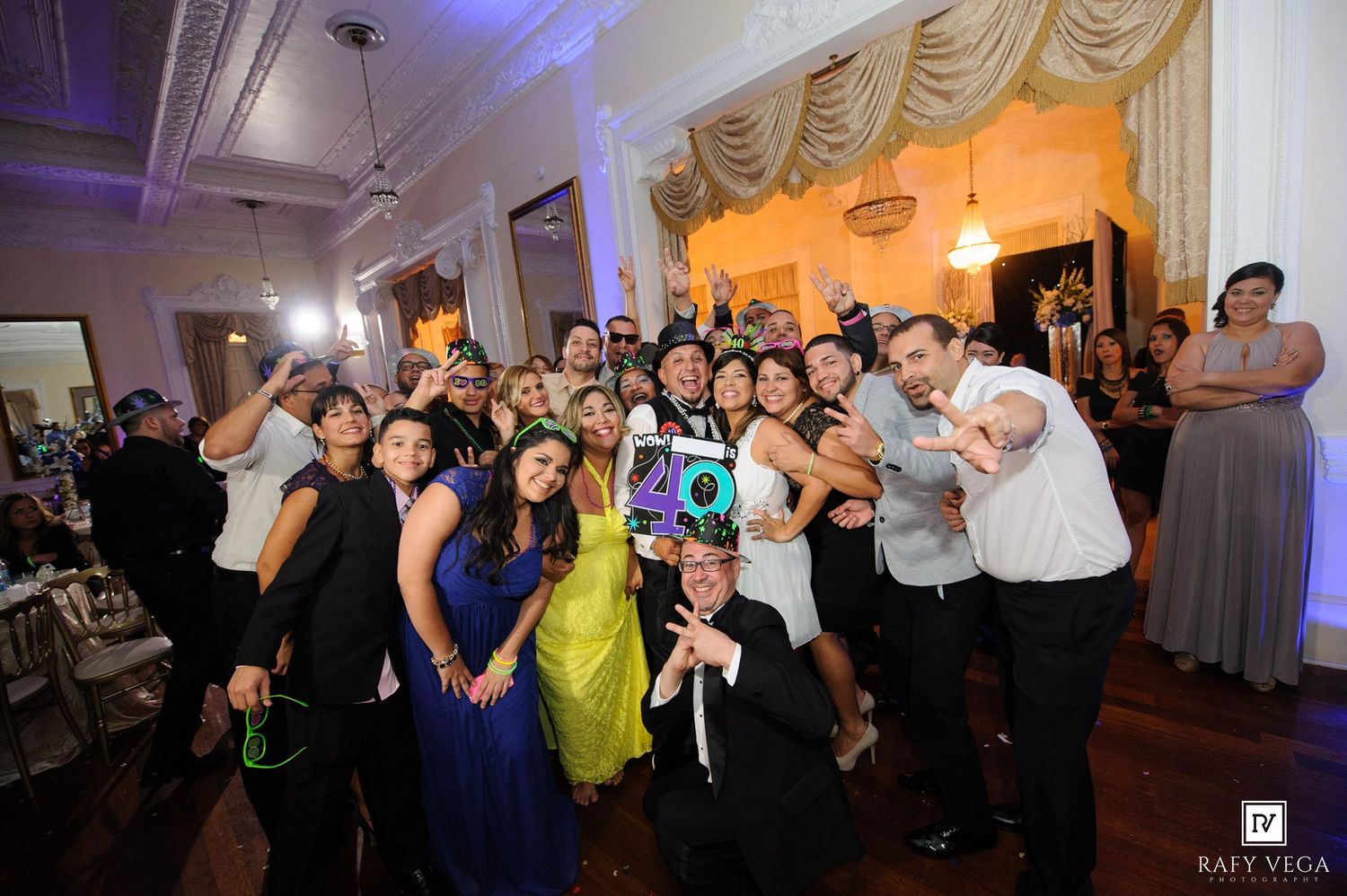 Large group of elegantly dressed guests celebrating a 40th birthday party at a formal indoor venue.