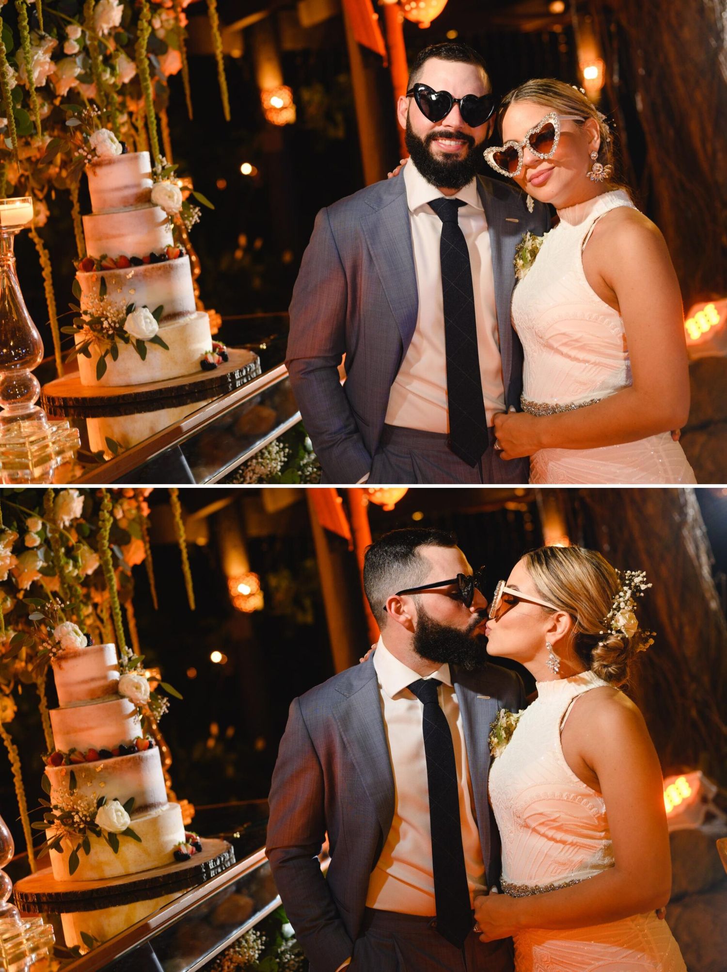 Bride and groom in sunglasses posing and kissing by a floral wedding cake at a romantic evening reception.