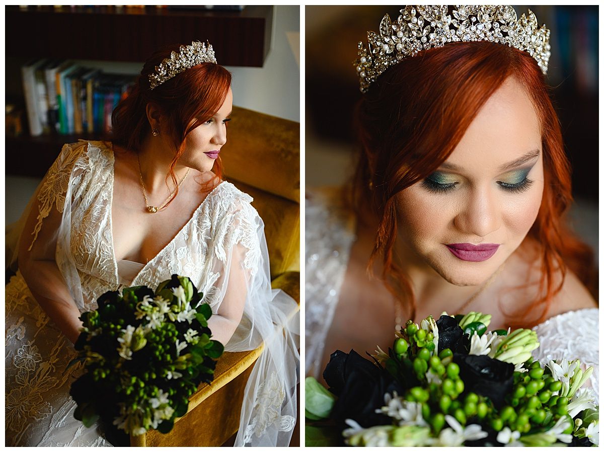 Red-haired bride wearing a crystal tiara and lace gown holds a bouquet of white and dark flowers on her wedding day.