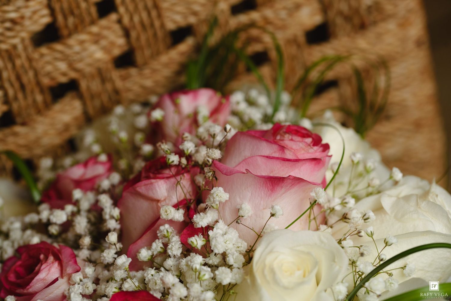 Close-up of pink and white roses with delicate baby's breath flowers arranged in a romantic wedding bouquet.