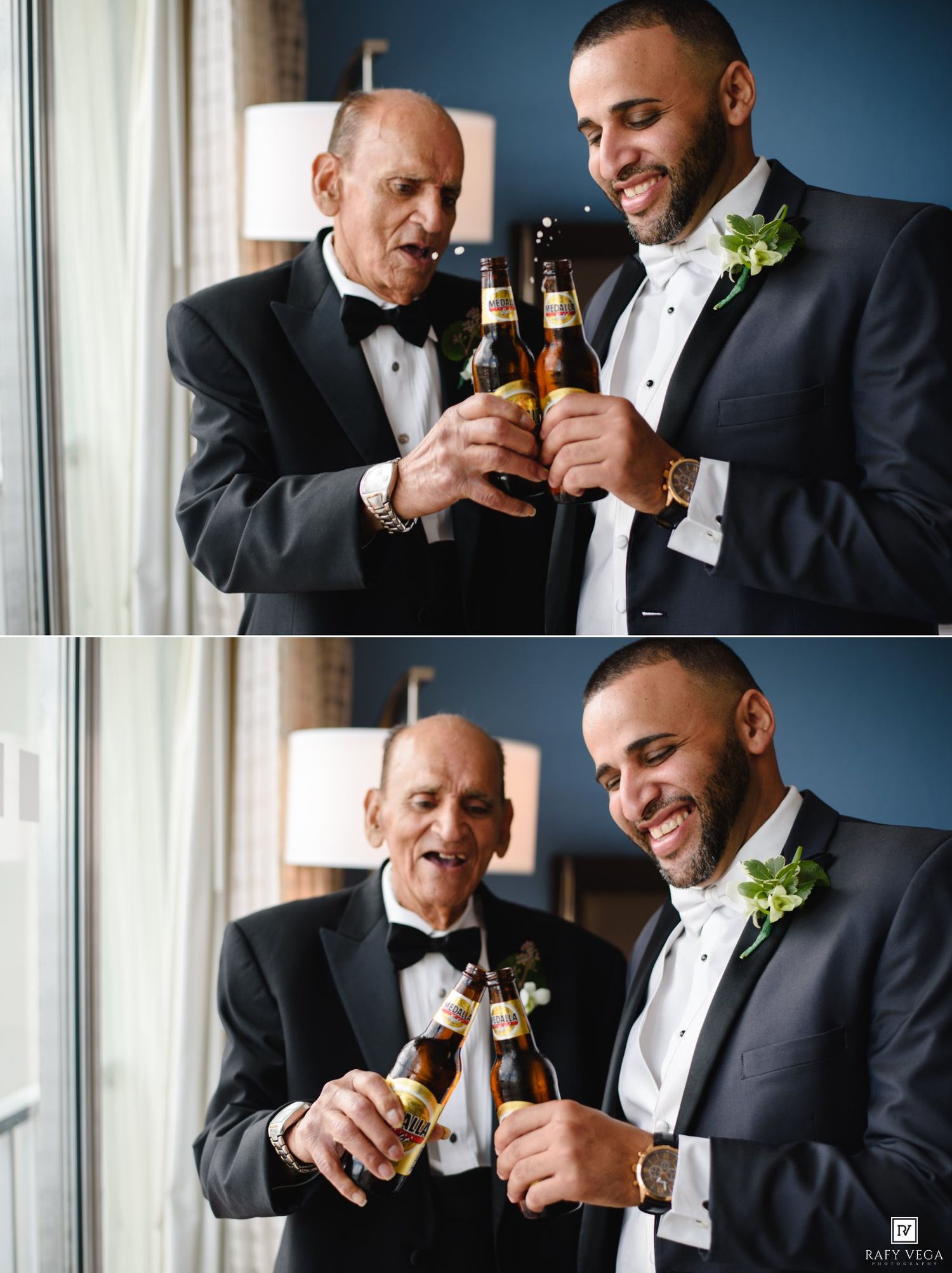Two men in tuxedos toasting with beer bottles at a wedding celebration near a window.