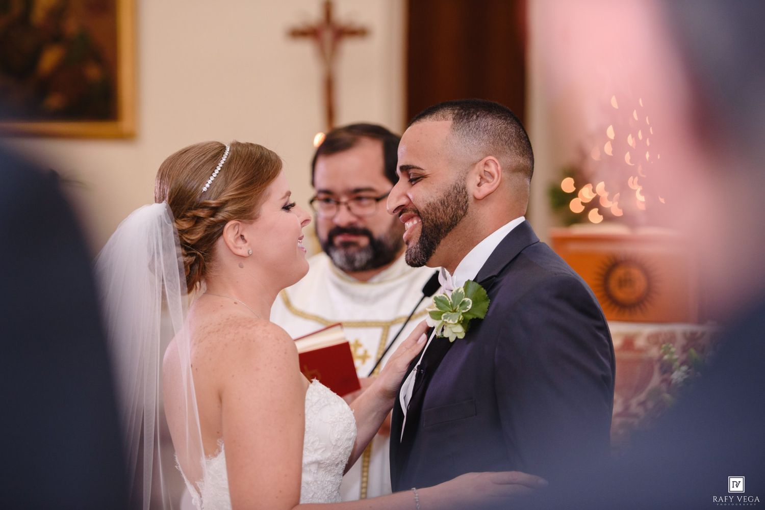 Bride and groom share intimate moment at altar during church wedding ceremony.