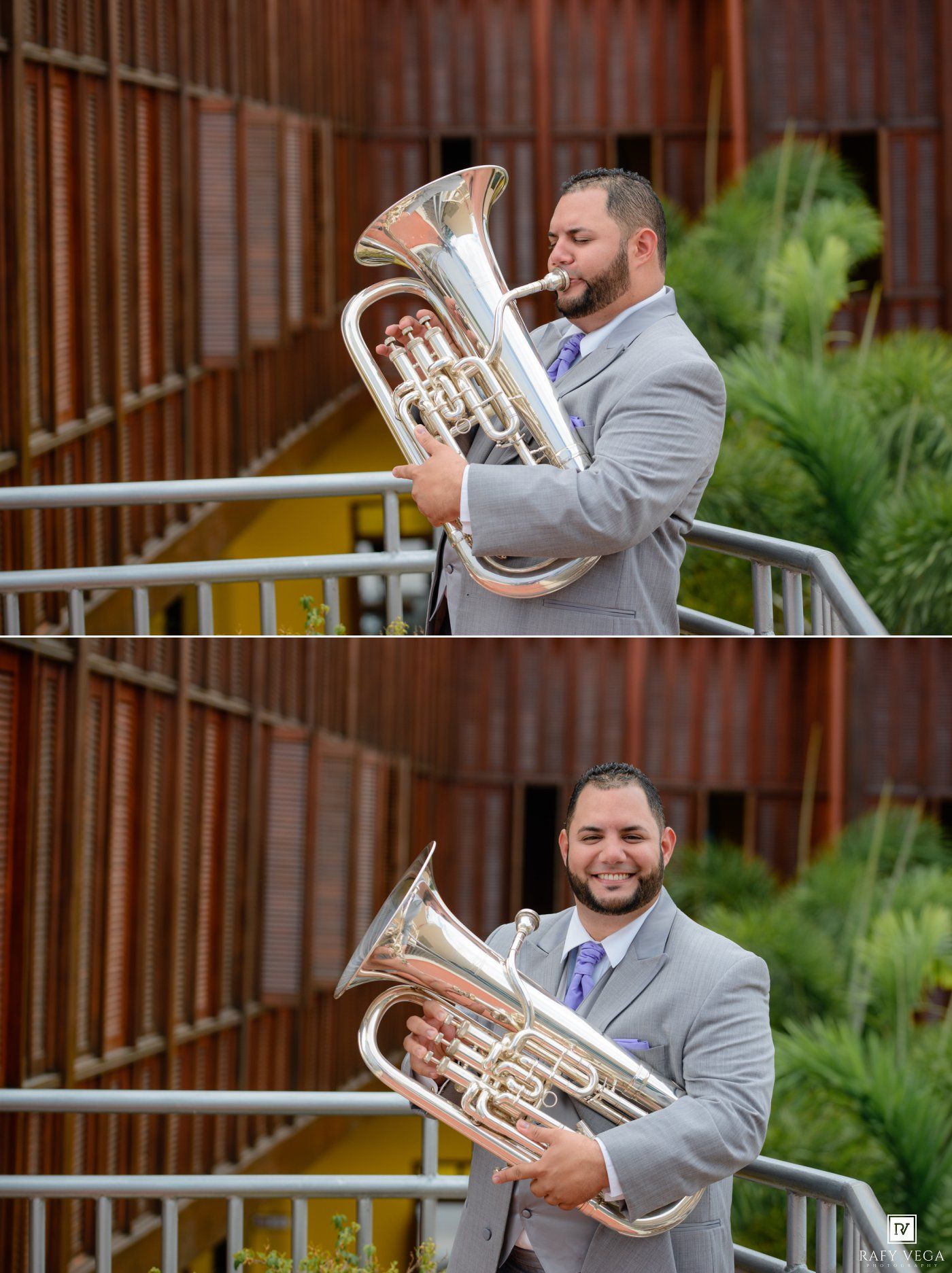 Man in gray suit playing a large brass euphonium instrument outdoors near modern architecture and tropical plants.