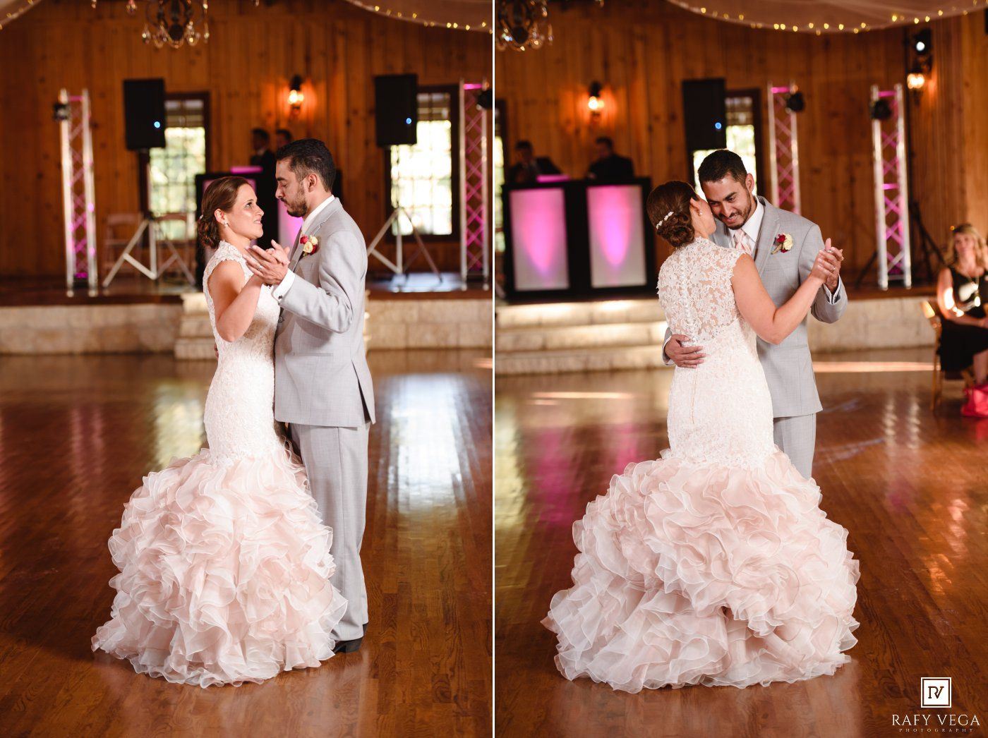 Bride in ruffled blush gown and groom in gray suit share first dance at elegant rustic wedding reception.