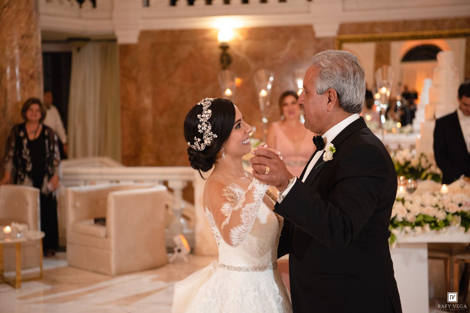 Bride and groom share a romantic first dance in an elegant ballroom during their wedding reception.
