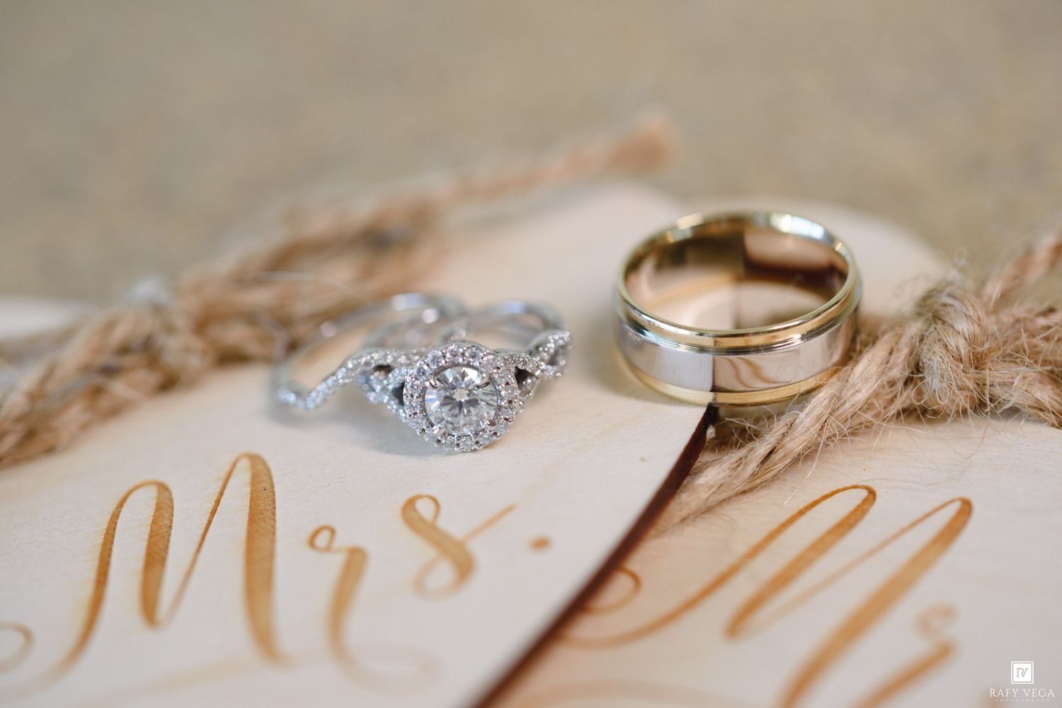 Wedding rings and diamond engagement ring displayed on Mrs. and Mr. calligraphy card with dried pampas grass.