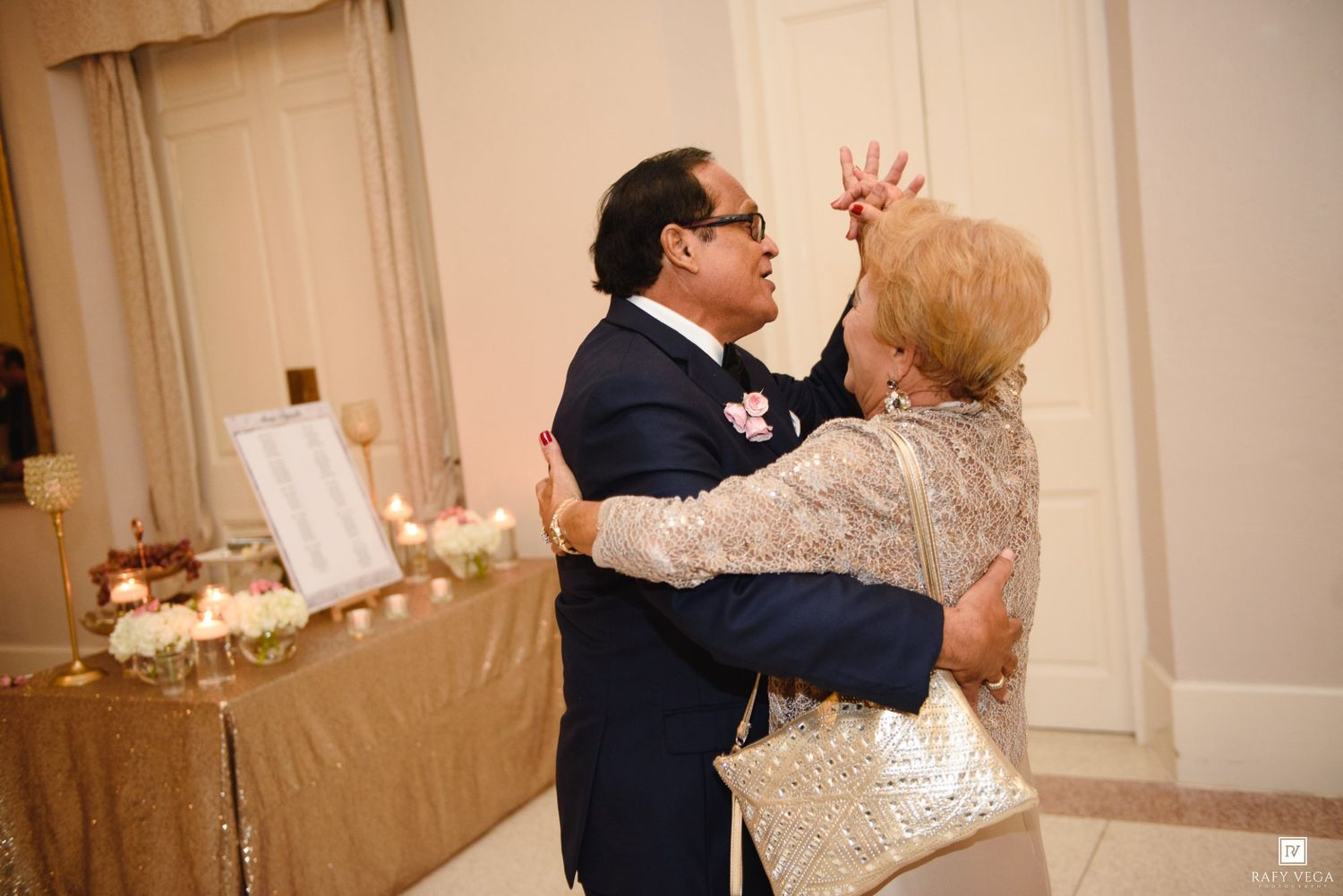 Couple dancing elegantly at a formal wedding reception in a beautifully decorated ballroom.
