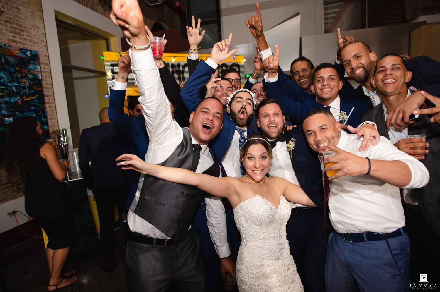 Bride and groom celebrate joyfully with groomsmen at wedding reception.