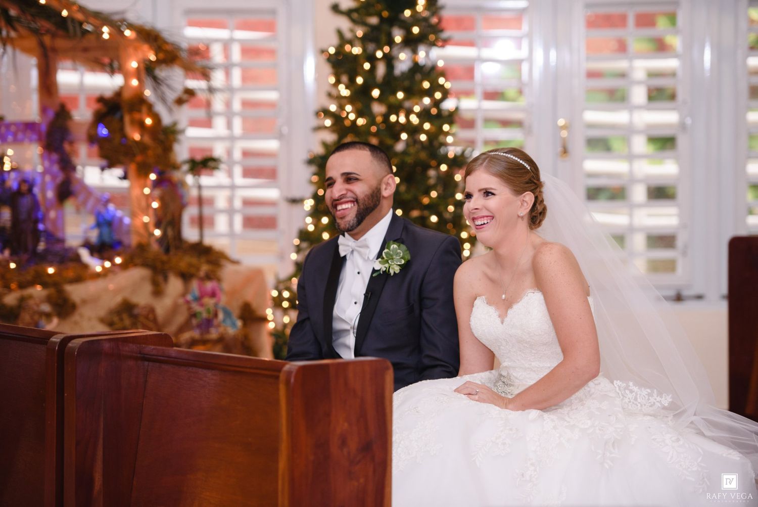 Bride and groom smile together at Christmas decorated wedding reception.