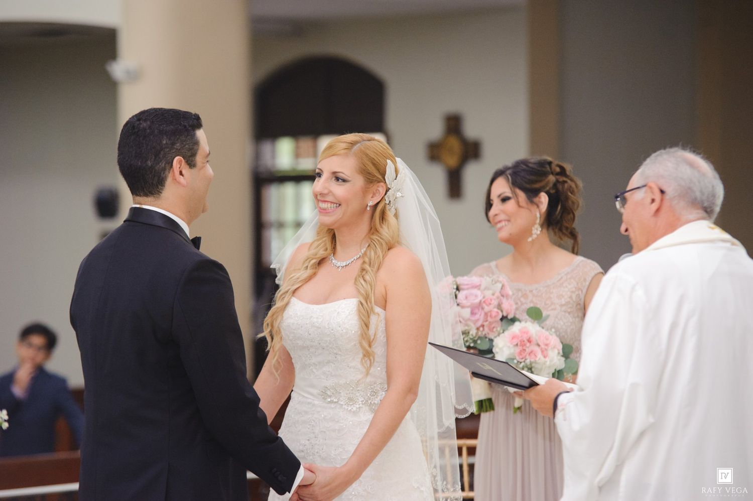 Bride and groom exchange vows at church altar with bridesmaid and officiant during elegant wedding ceremony.