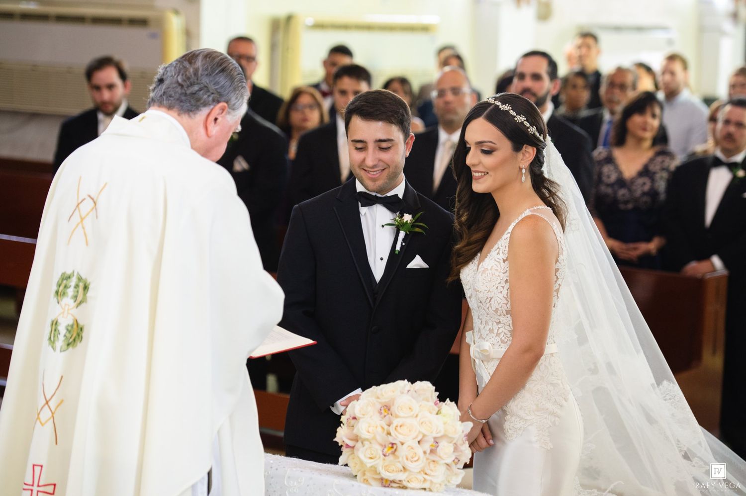 Bride and groom exchange vows before a priest at a traditional church wedding ceremony.