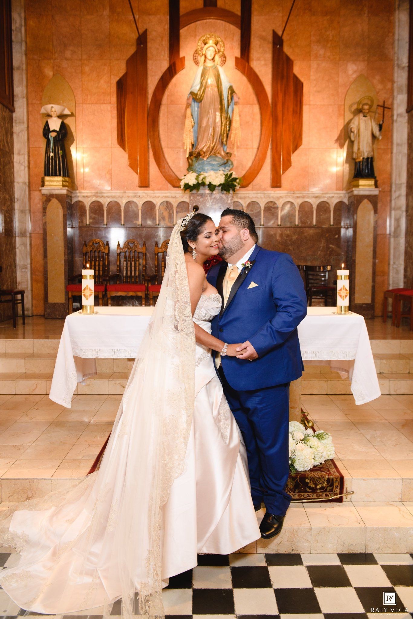 Bride and groom share a romantic kiss at the altar of a beautiful church on their wedding day.