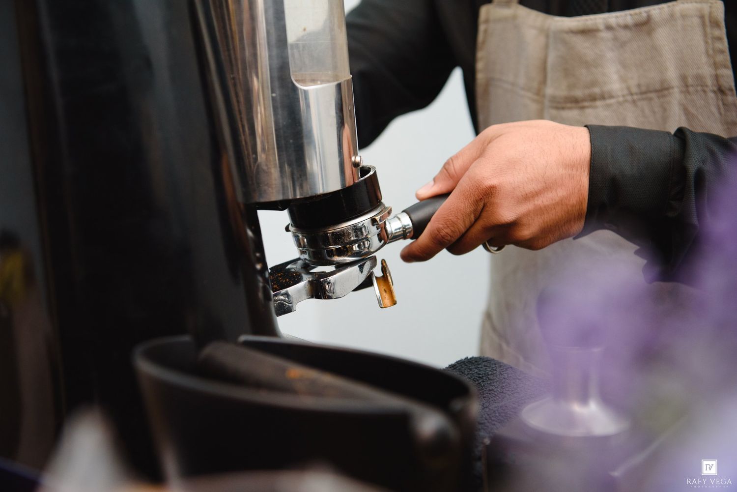 Barista using a professional espresso machine to prepare a fresh coffee drink.
