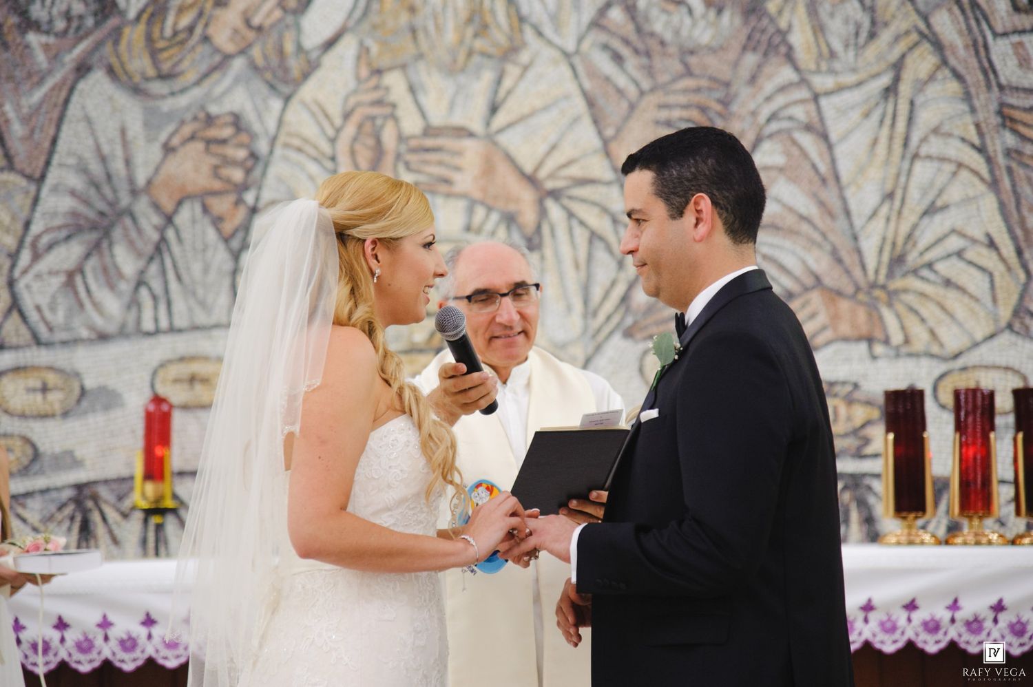 Bride and groom exchange vows at church altar with officiant during elegant wedding ceremony.