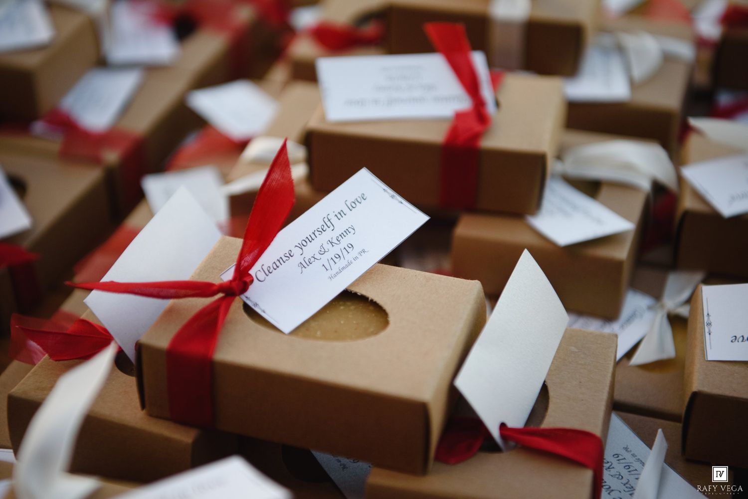 Brown kraft paper gift boxes tied with red ribbons and white gift tags arranged on a table.
