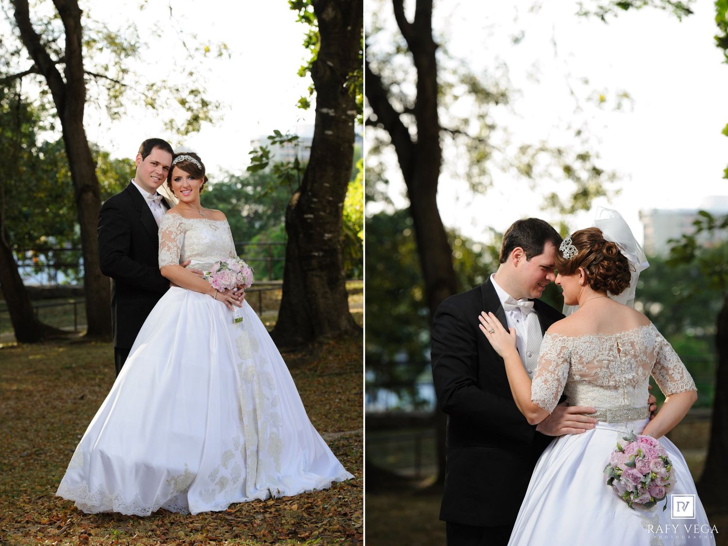 Bride in white off-shoulder gown and groom in black tuxedo pose together outdoors among trees on their wedding day.