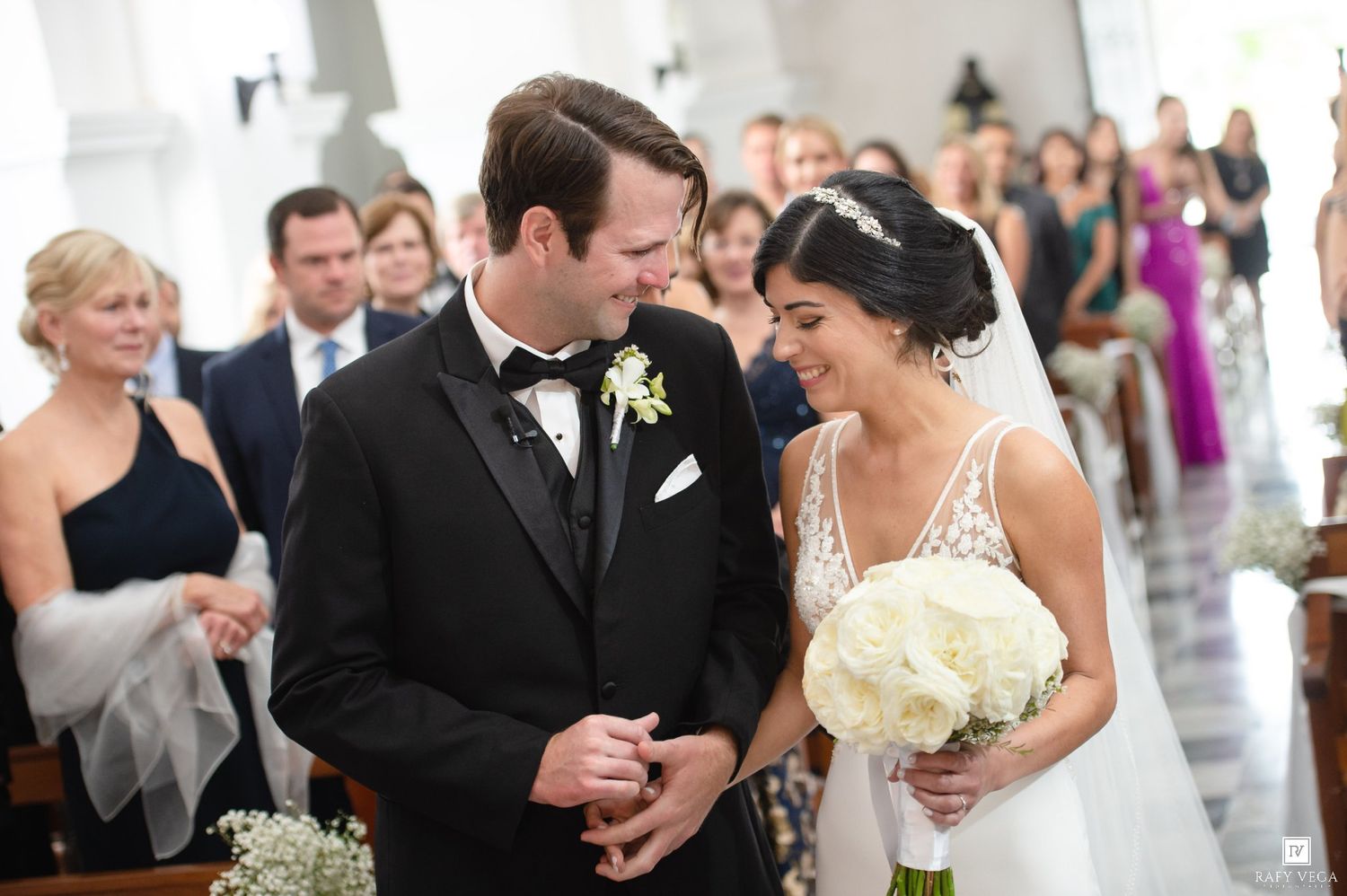 Bride and groom share a joyful moment at the altar during their elegant church wedding ceremony.