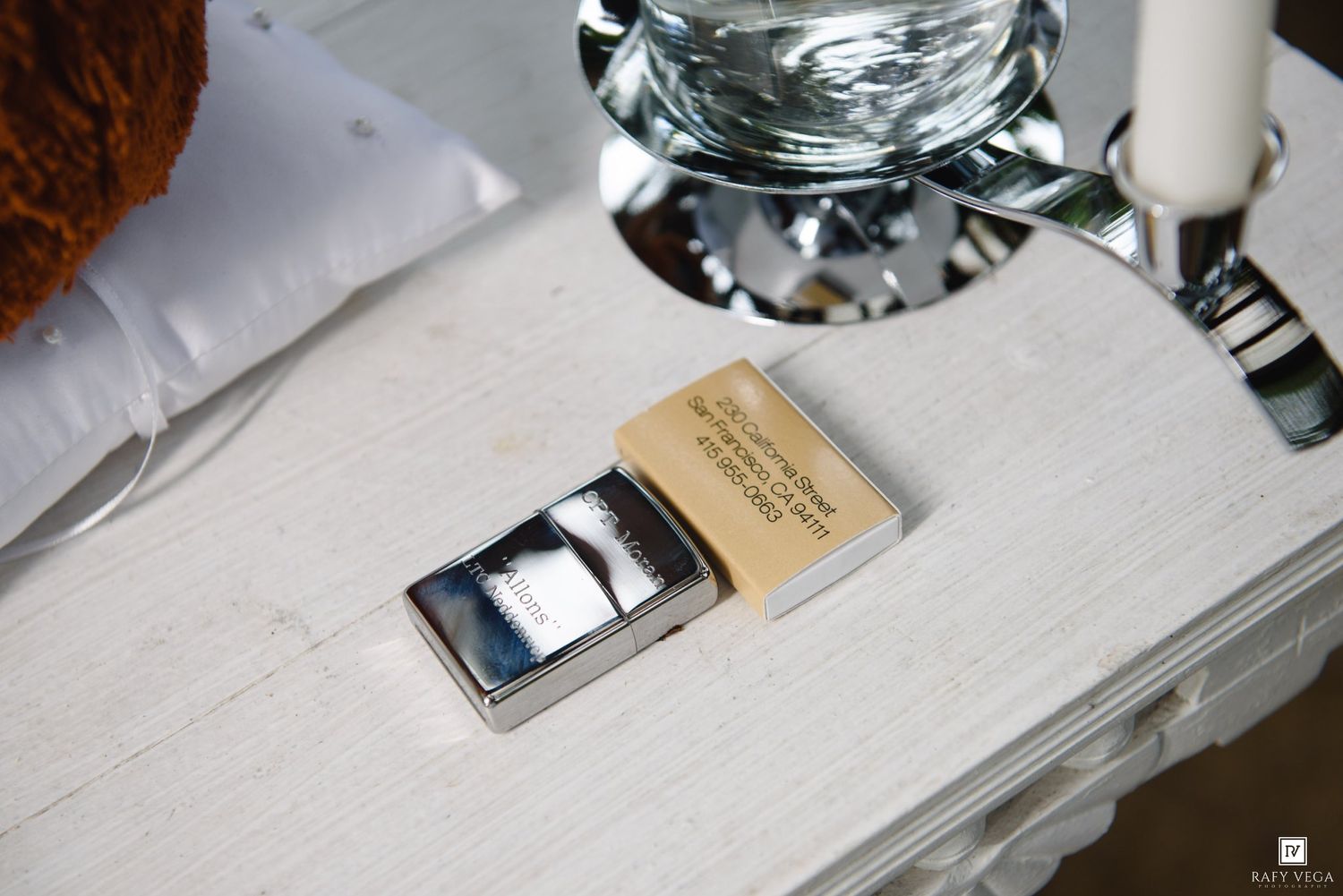 Gold engraved keepsake box with silver cufflinks displayed on white table at wedding reception.
