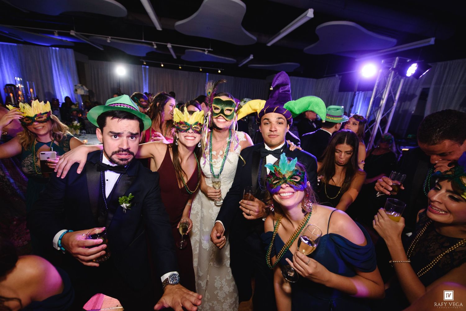 Group of party guests wearing colorful masquerade masks at a festive Mardi Gras themed celebration.