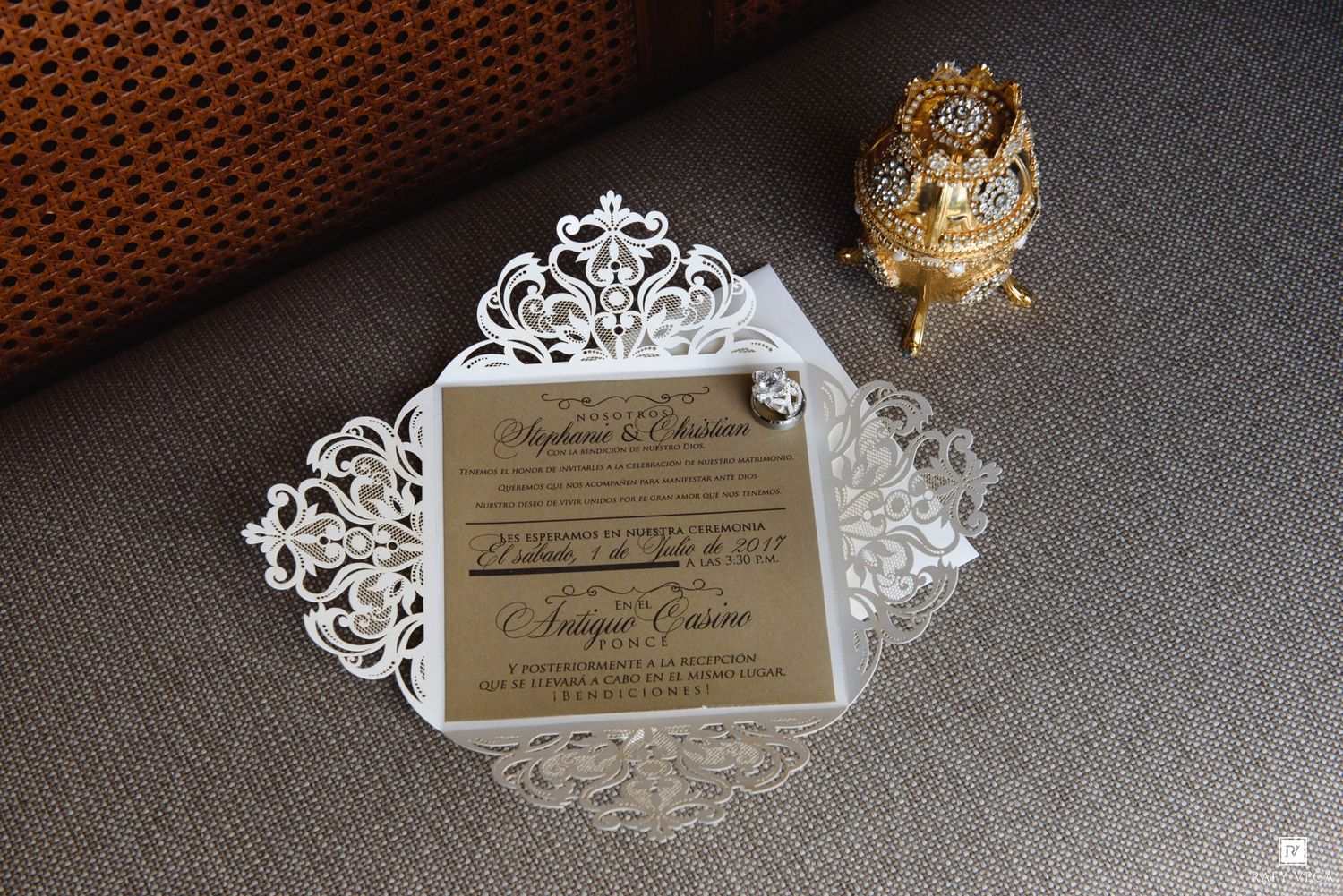 Elegant laser-cut white wedding invitation with gold mirror card and ornate jeweled trinket box on neutral background.
