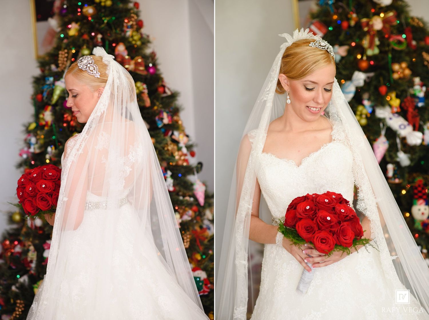 Bride in white wedding gown and veil holding red rose bouquet standing before a decorated Christmas tree.