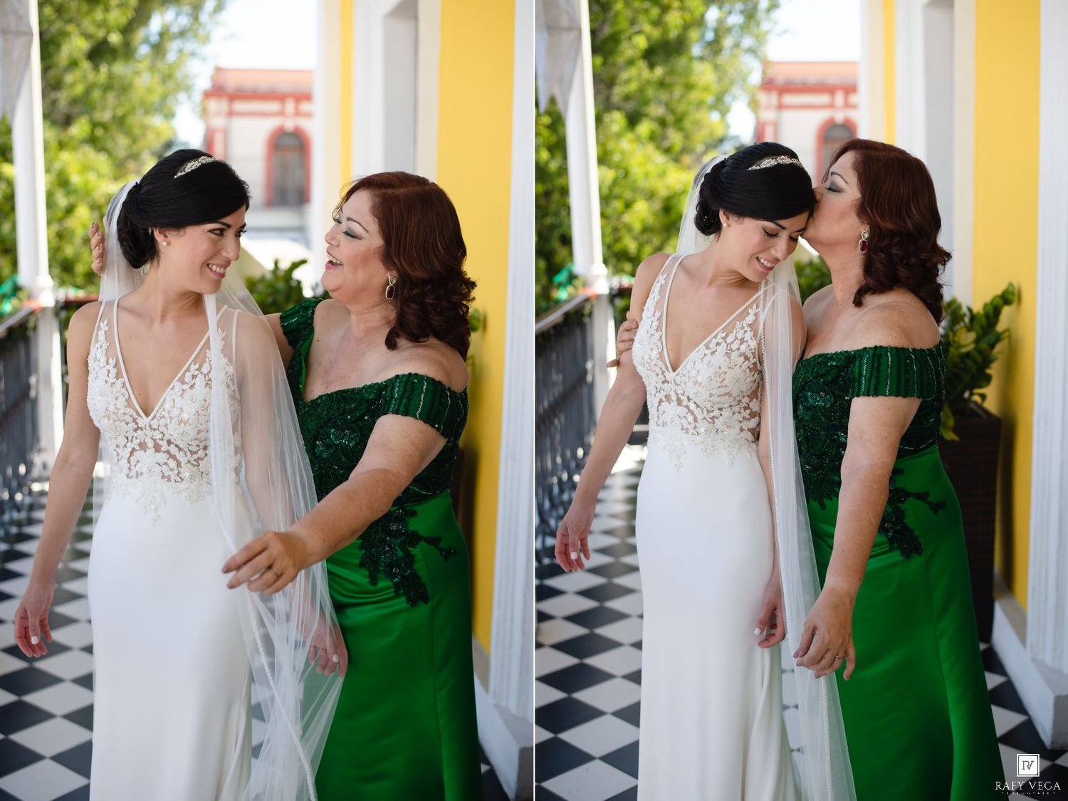 Bride in white gown with veil shares a tender moment with woman in emerald green off-shoulder dress on checkered floor.
