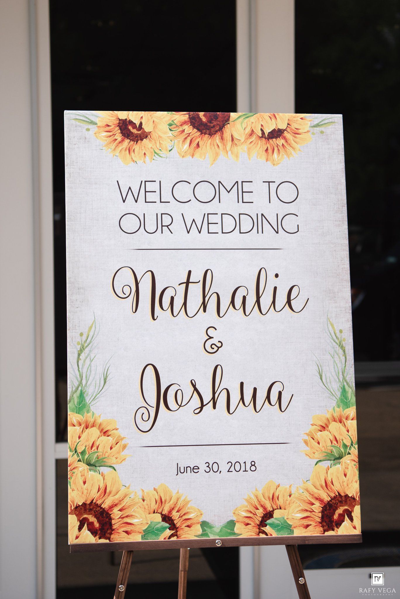 Sunflower-decorated wedding welcome sign for Nathalie and Joshua on June 30, 2018, displayed on a wooden easel.