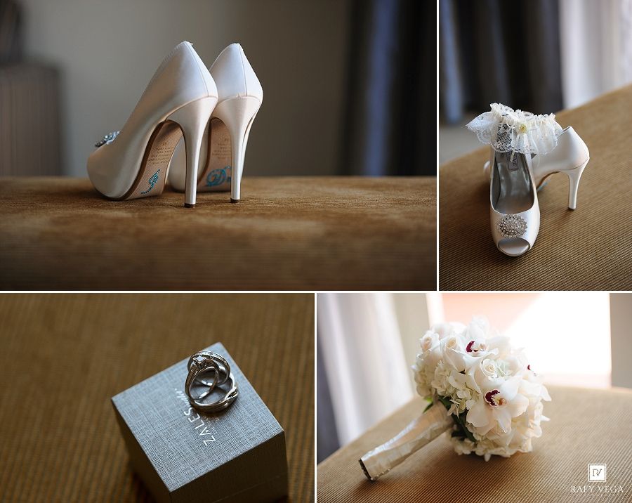 Elegant white bridal heels, diamond ring on box, and white floral bouquet displayed as wedding detail accessories.